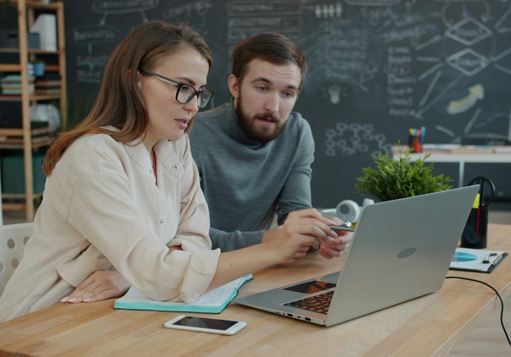 Formation en personne : formateur et cliente travaillent ensemble sur un ordinateur portable
